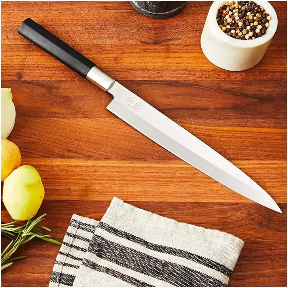 Knife on a wooden cutting board with fruits and a towel