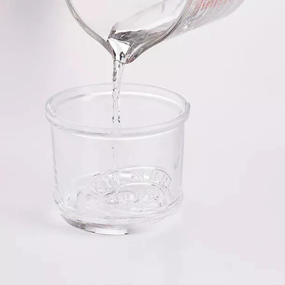 Clear glass container with a brand logo being filled with water on a white background