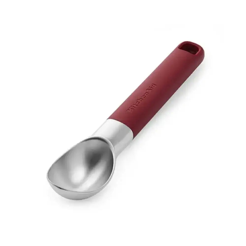 Metallic ice cream scoop with a red handle on a white background