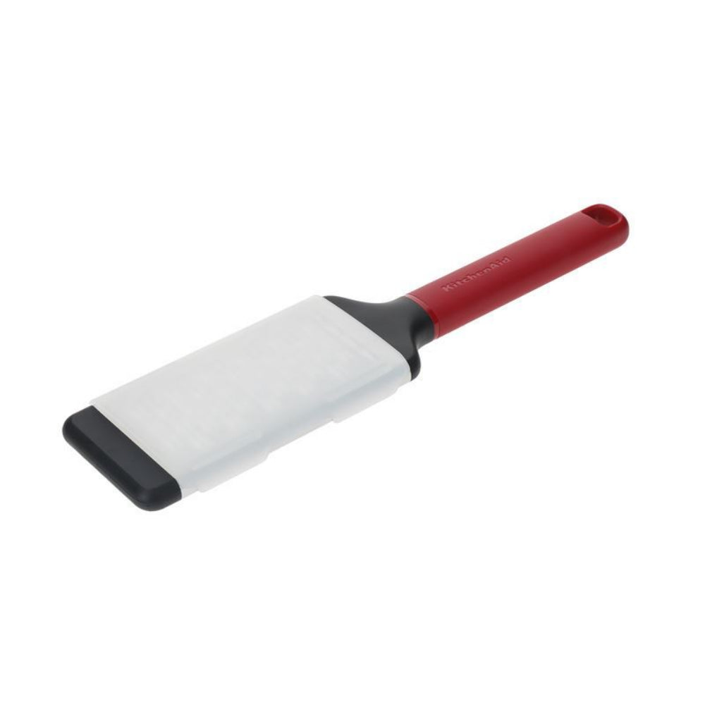 Zester with red handle and white blade on a white background