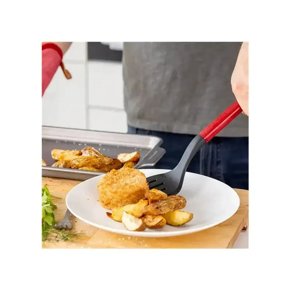 Person eating fried food with a fork on a white plate, blurred background
