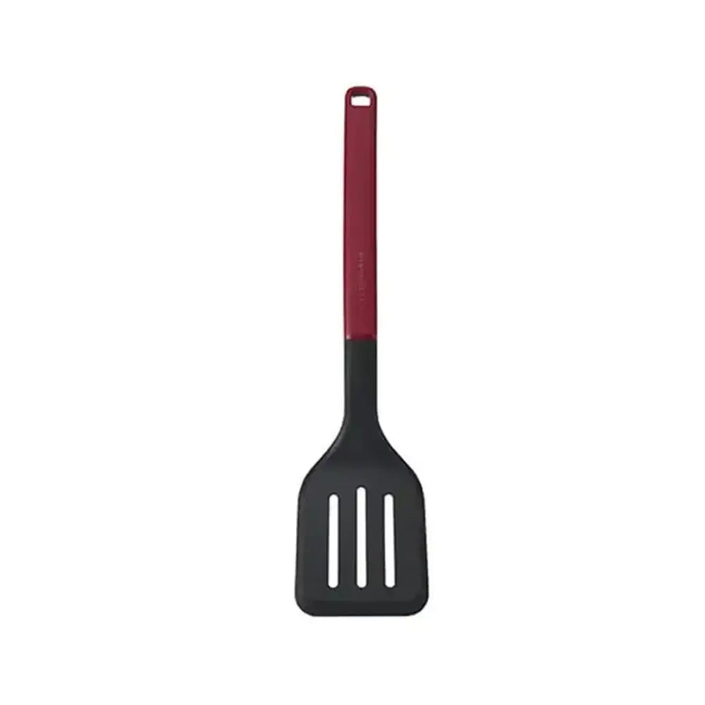 Black slotted spatula with red handle on a white background