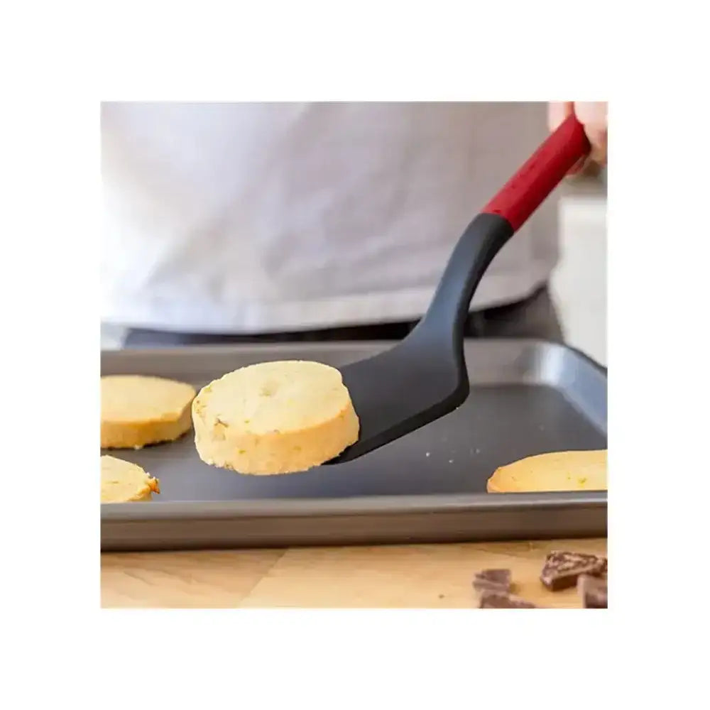 Person using a spatula to flip pancakes on a griddle.