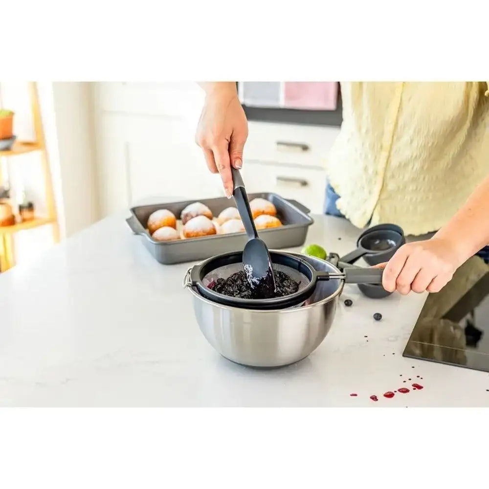 Person preparing food in a kitchen with various utensils and ingredients.