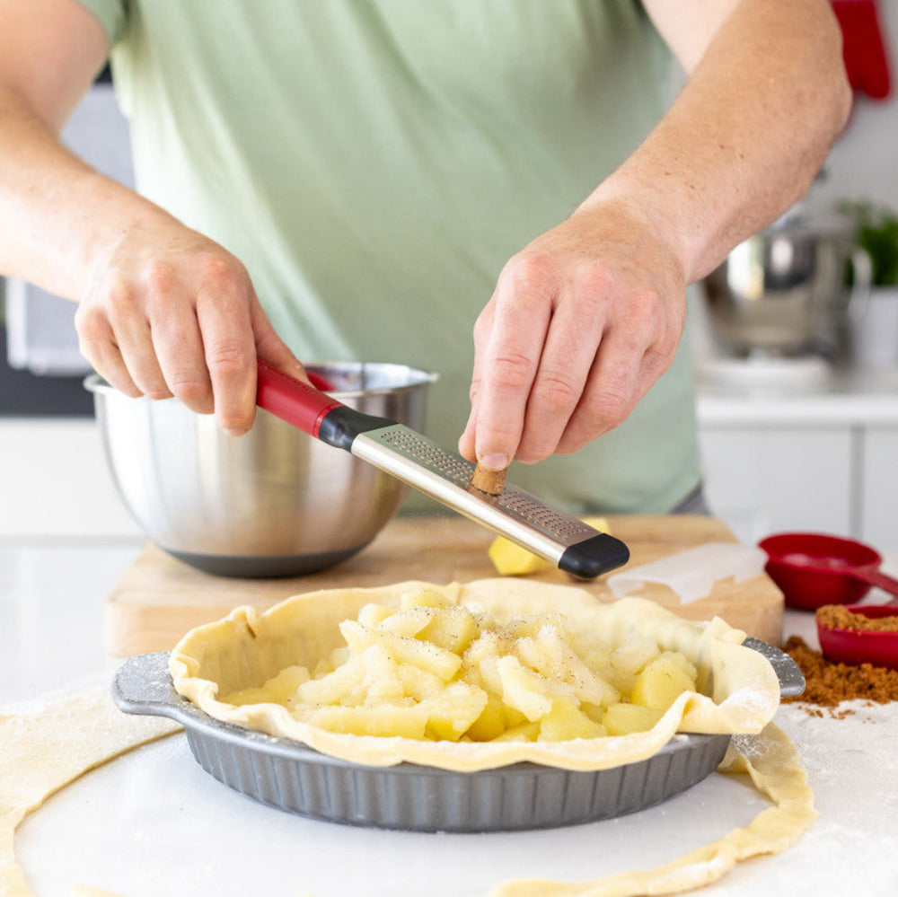 Person preparing a pie in a kitchen