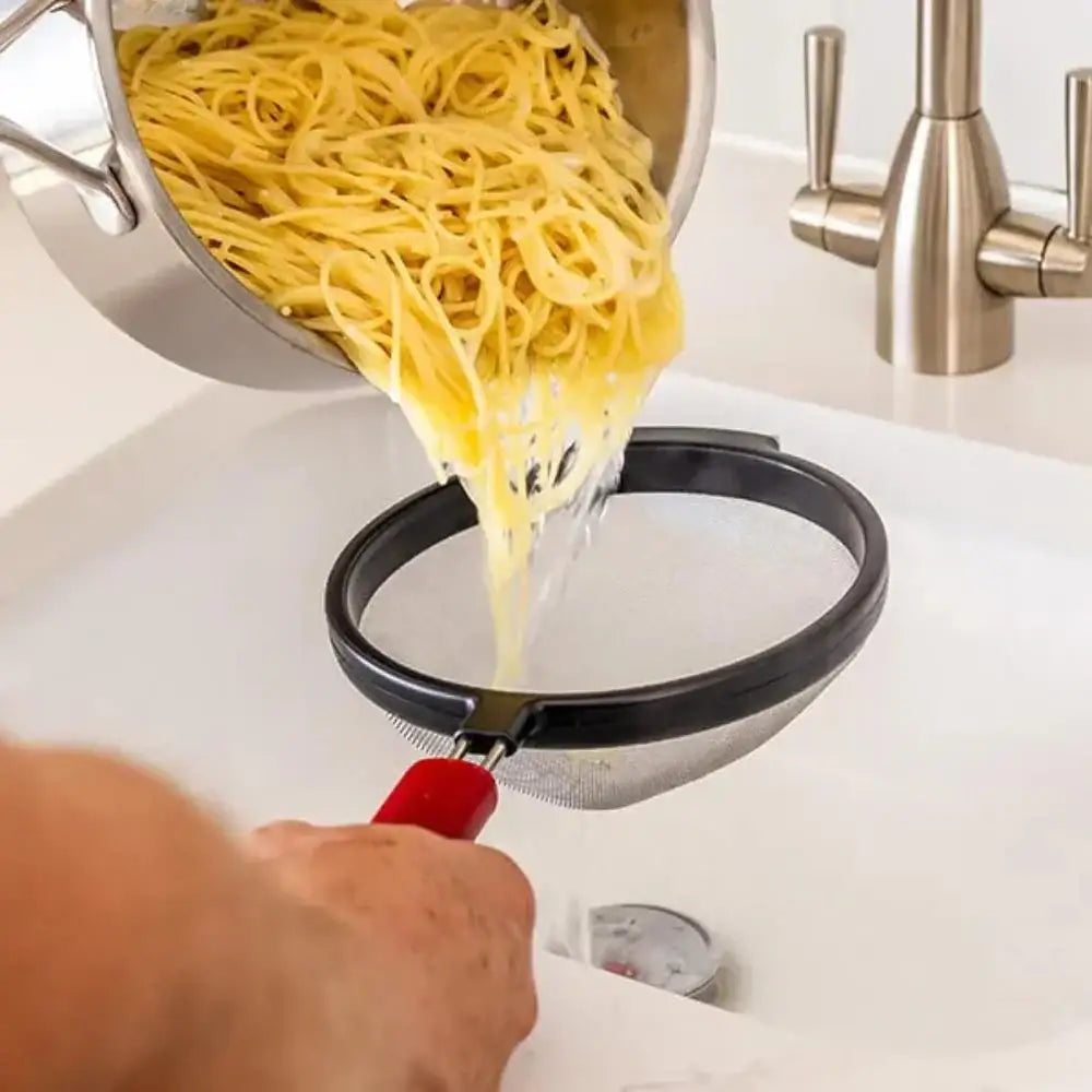 Person draining cooked spaghetti into a colander over a sink.