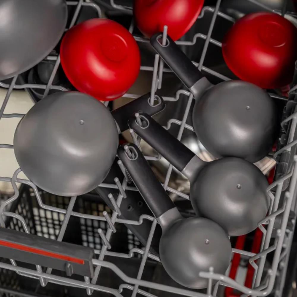 Dishwasher rack with red and gray ladles inside