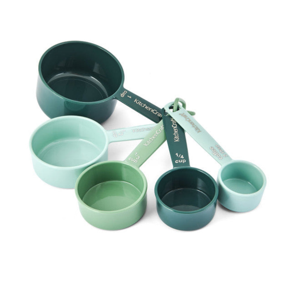 Set of green measuring cups on a white background