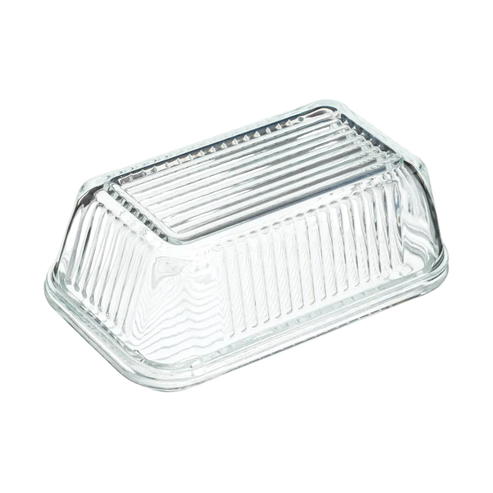 A clear glass butter dish with a ribbed lid and fluted sides, shown on a plain white background.