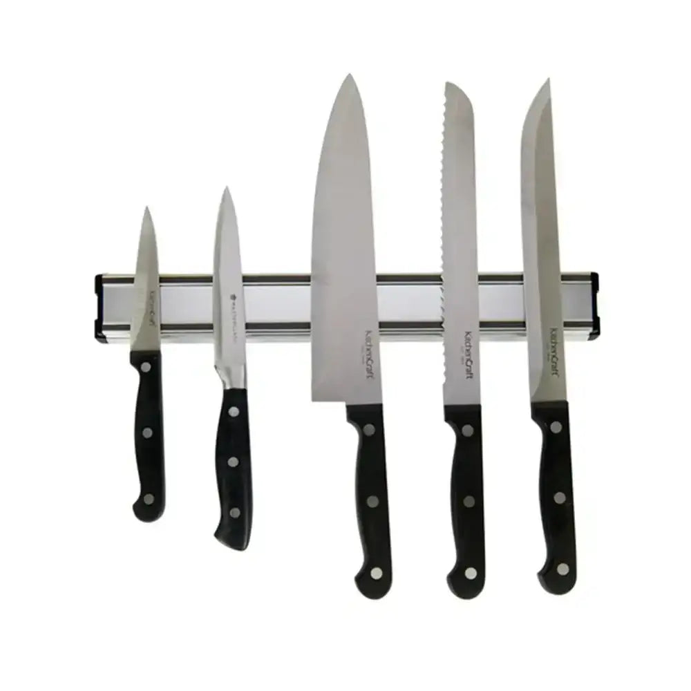 Set of knives on a magnetic strip with a white background