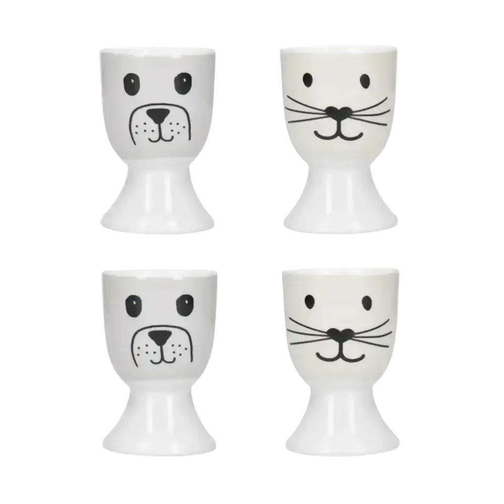 Four white egg cups with black animal face designs on a white background