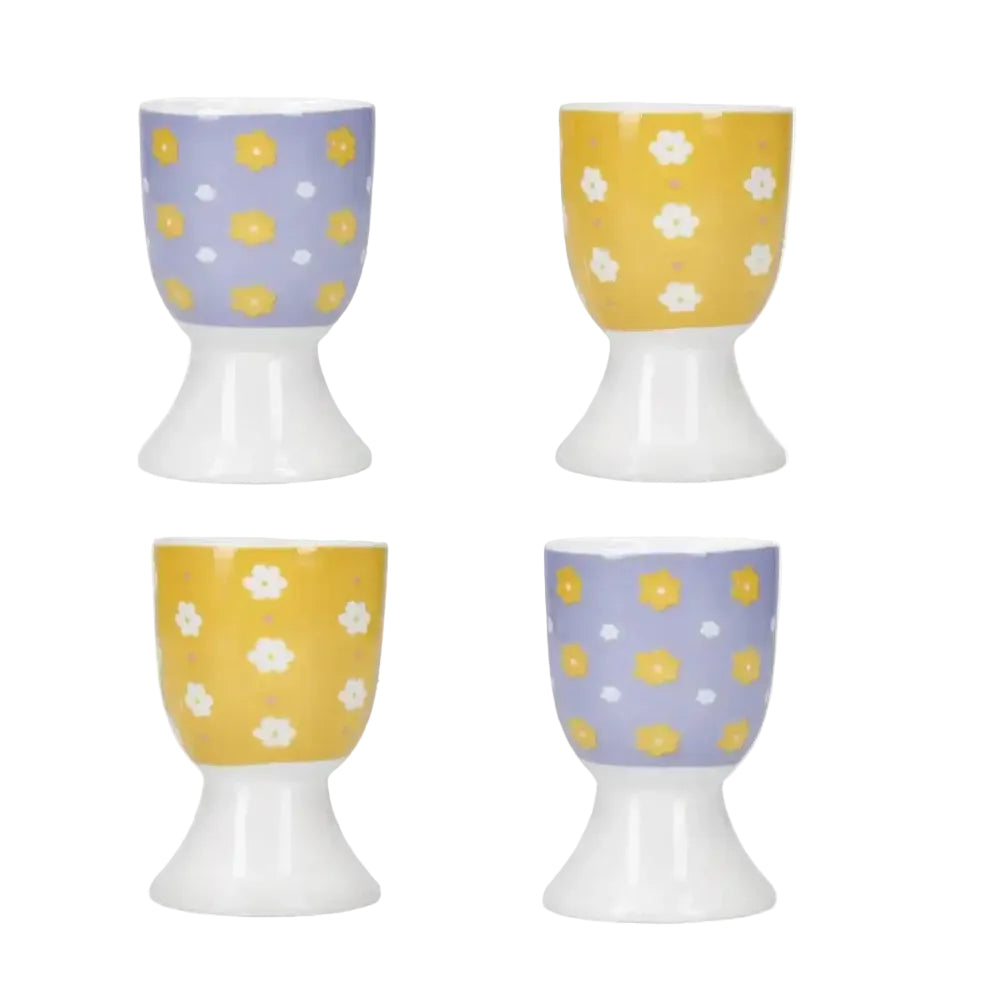 Four ceramic egg cups with floral patterns on a white background