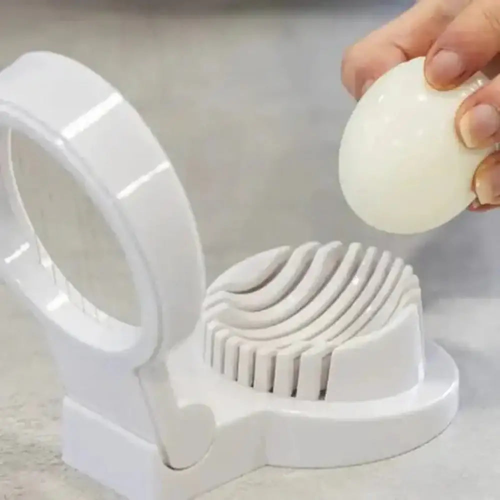 White egg slicer with a hand holding an egg on a light gray background
