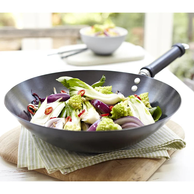 KitchenCraft Oriental carbon steel non-stick wok with fresh vegetables on table, Cookin Stores