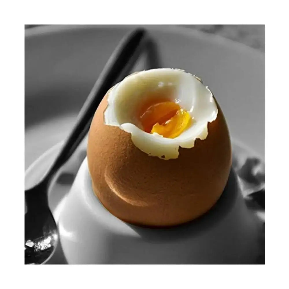 Hard-boiled egg with a cracked shell on a white plate with a gray background