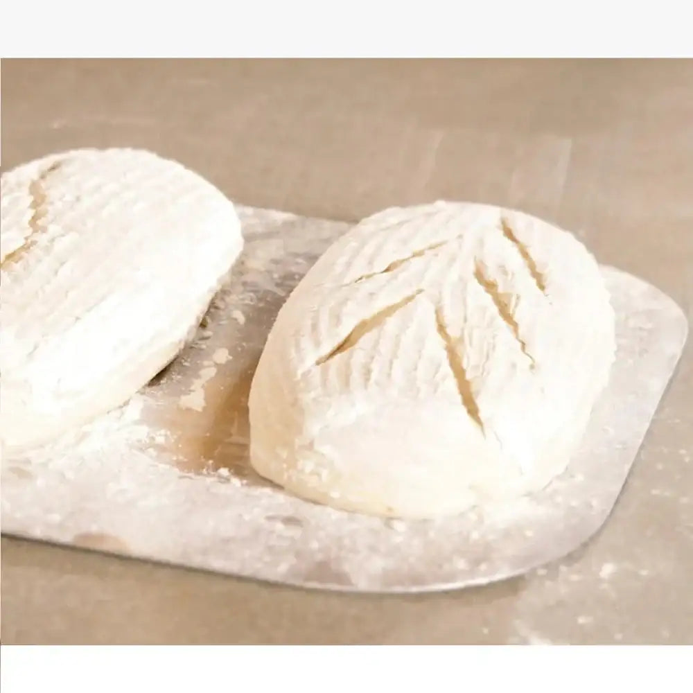 Two pieces of dough on a floured surface with a beige background