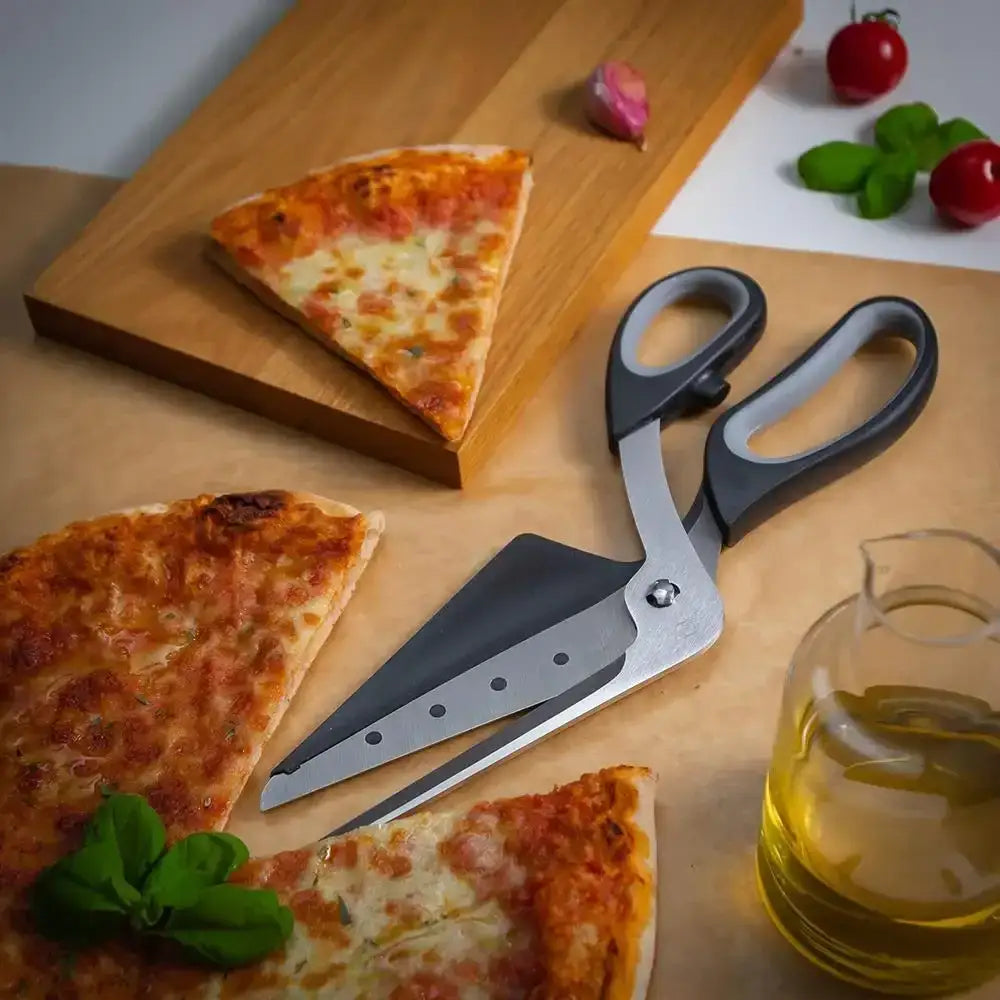 Pizza slices on a wooden board with a pair of pizza scissors and a glass of oil.