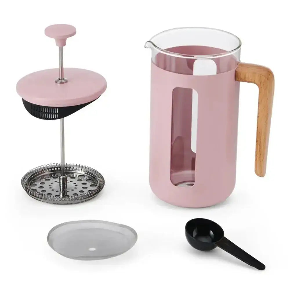 Pink French press coffee maker with wooden handle and accessories on a white background