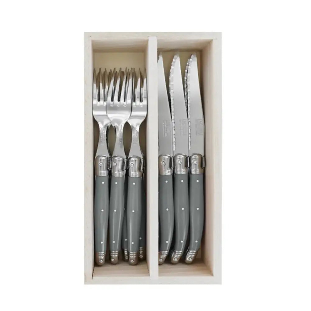 Set of gray cutlery with silver handles in a wooden box on a white background