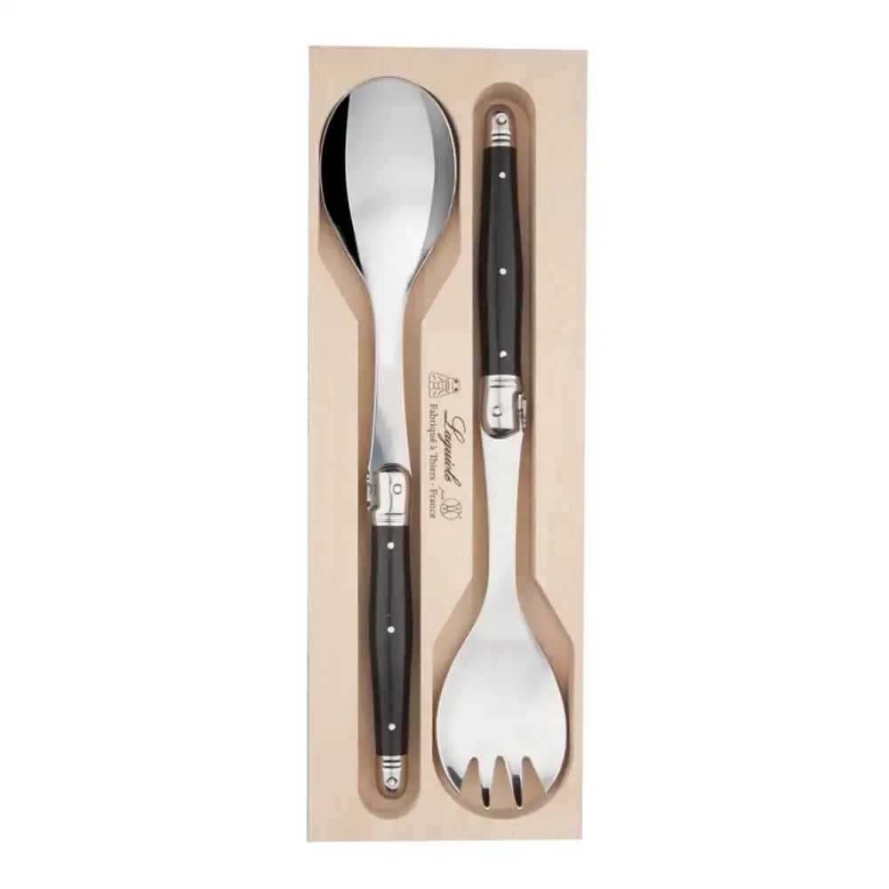 Set of silver spoon and fork with black handles in a cardboard box on a white background