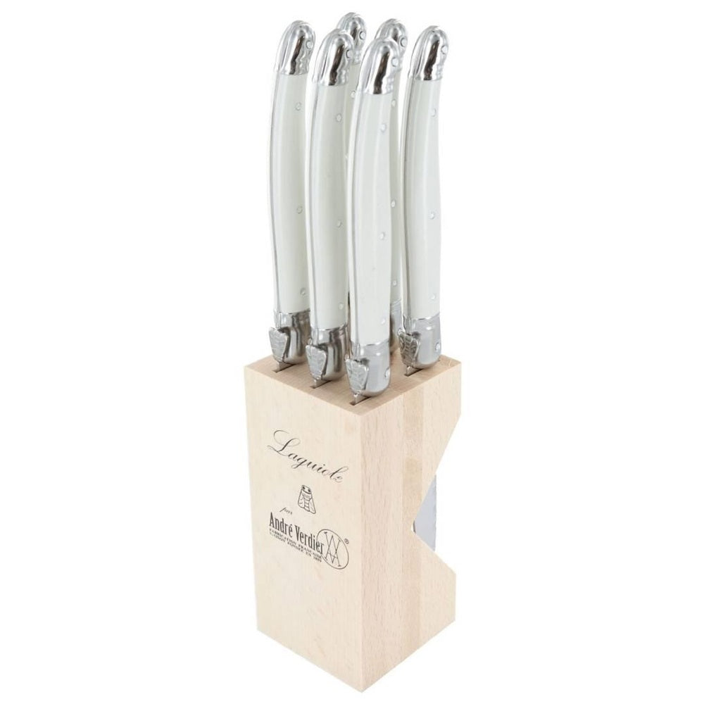 Set of knives with white handles in a wooden block on a white background