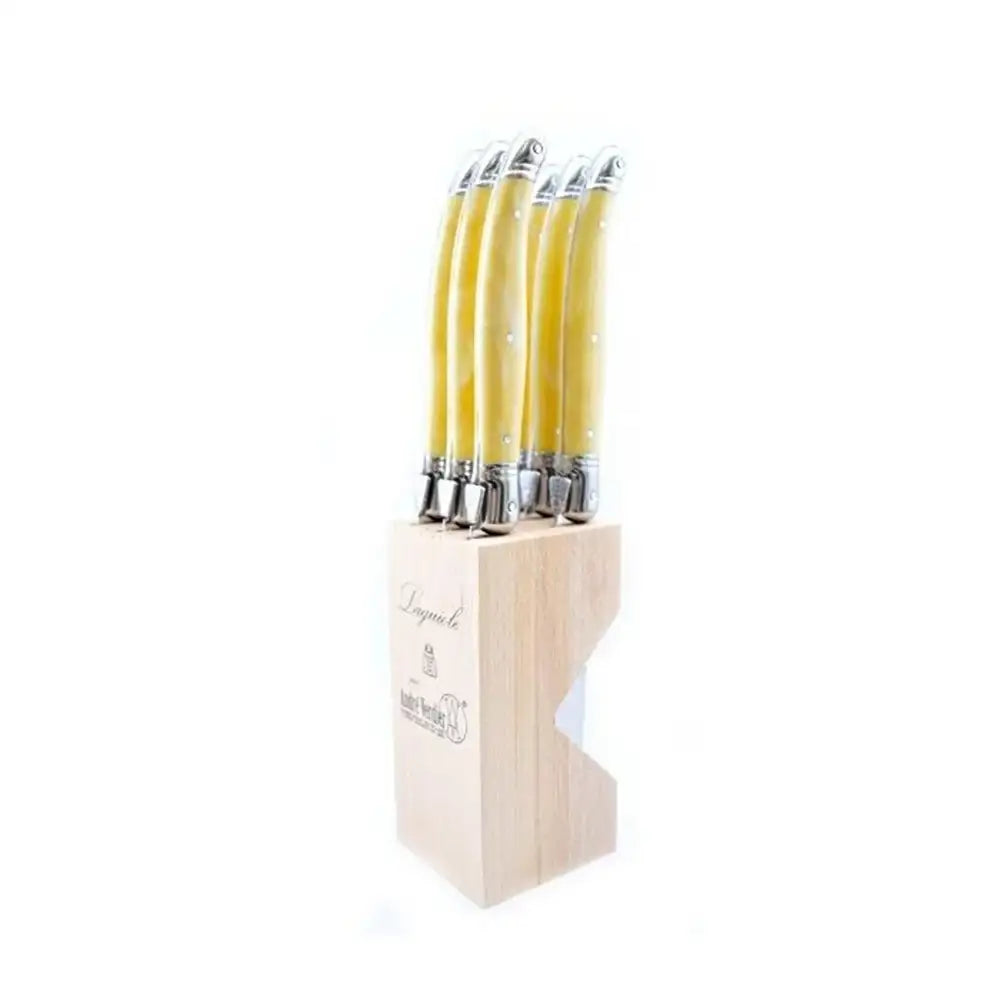 Set of knives with yellow handles in a wooden block on a white background