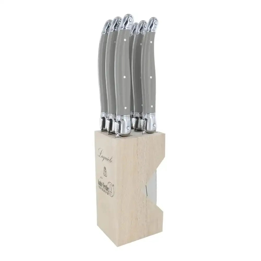 Set of knives with gray handles in a wooden block on a white background