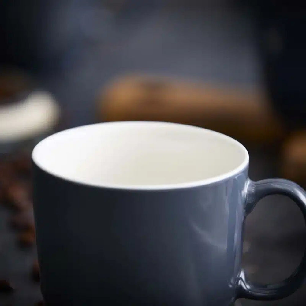 Gray mug with steam on a blurred background