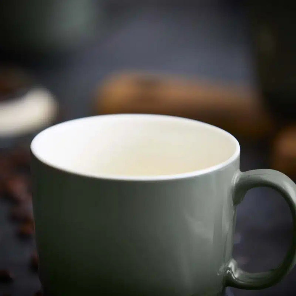 White mug with steam rising, blurred background