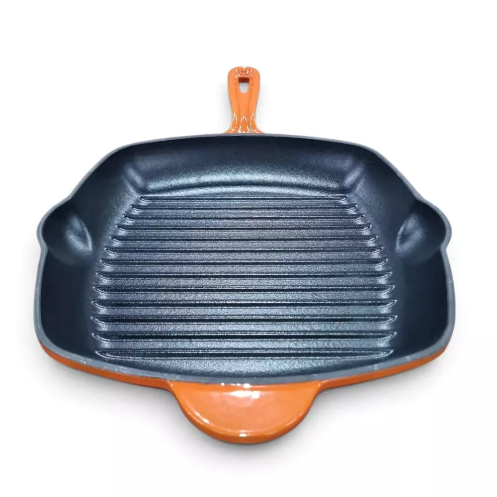 A Le Morgan Cast Iron Grill Pan 28cm Flame Orange with a dark gray non-stick interior and a glossy orange exterior, featuring a handle and side grips, shown on a white background.