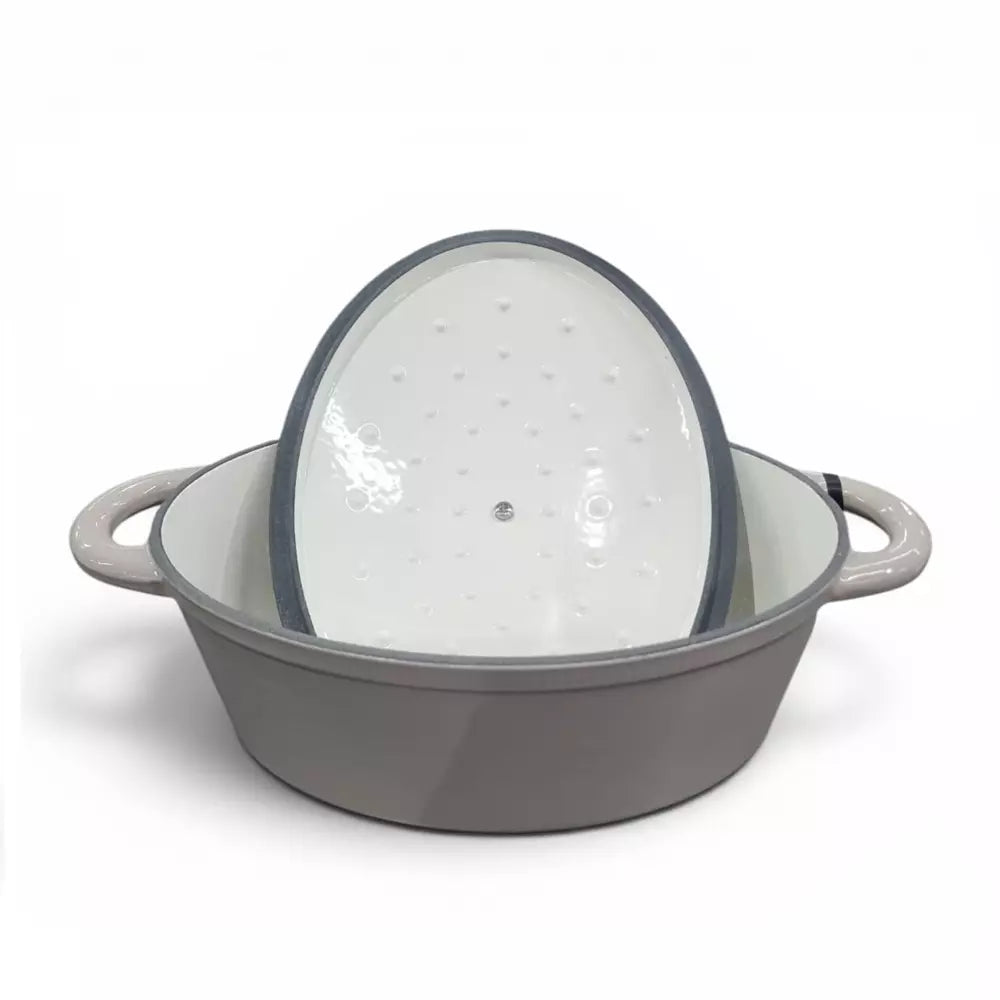 Beige cast iron enamel casserole pot with lid on a white background