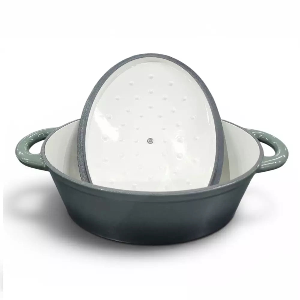 Green cast iron casserole pot with a lid on a white background