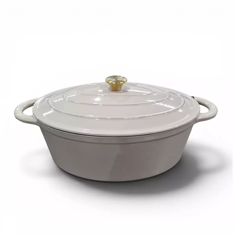 Beige cast iron cooking pot with gold knob on lid on a white background