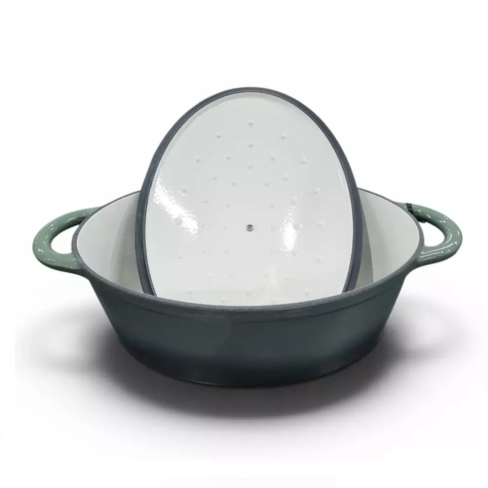 Green enameled cast iron pot with a glass lid on a white background