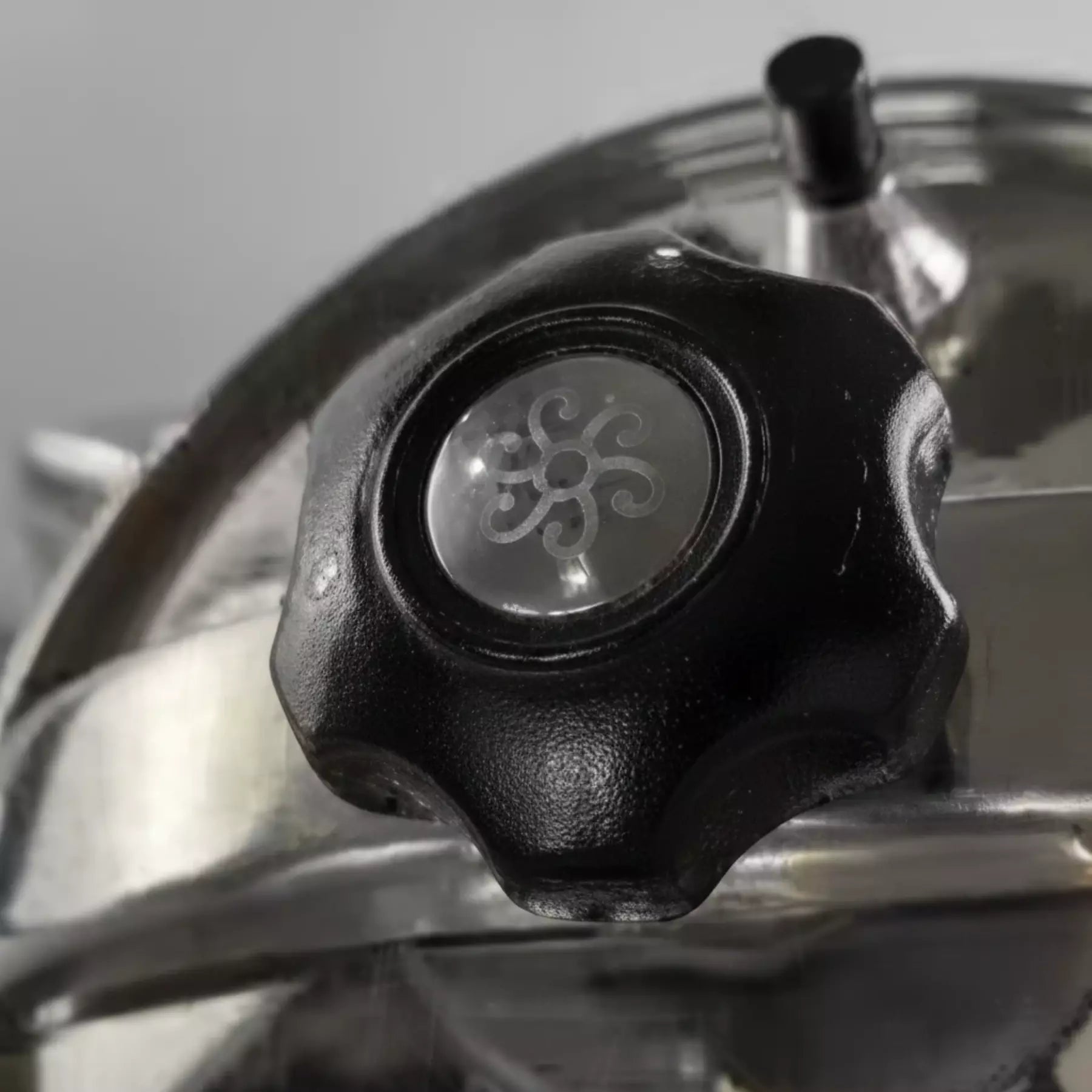 Pressure cooker lid close up with pressure release valve in the background