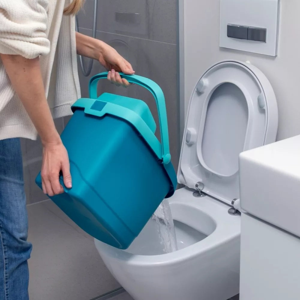 Person using a blue bucket to flush a toilet in a bathroom setting.