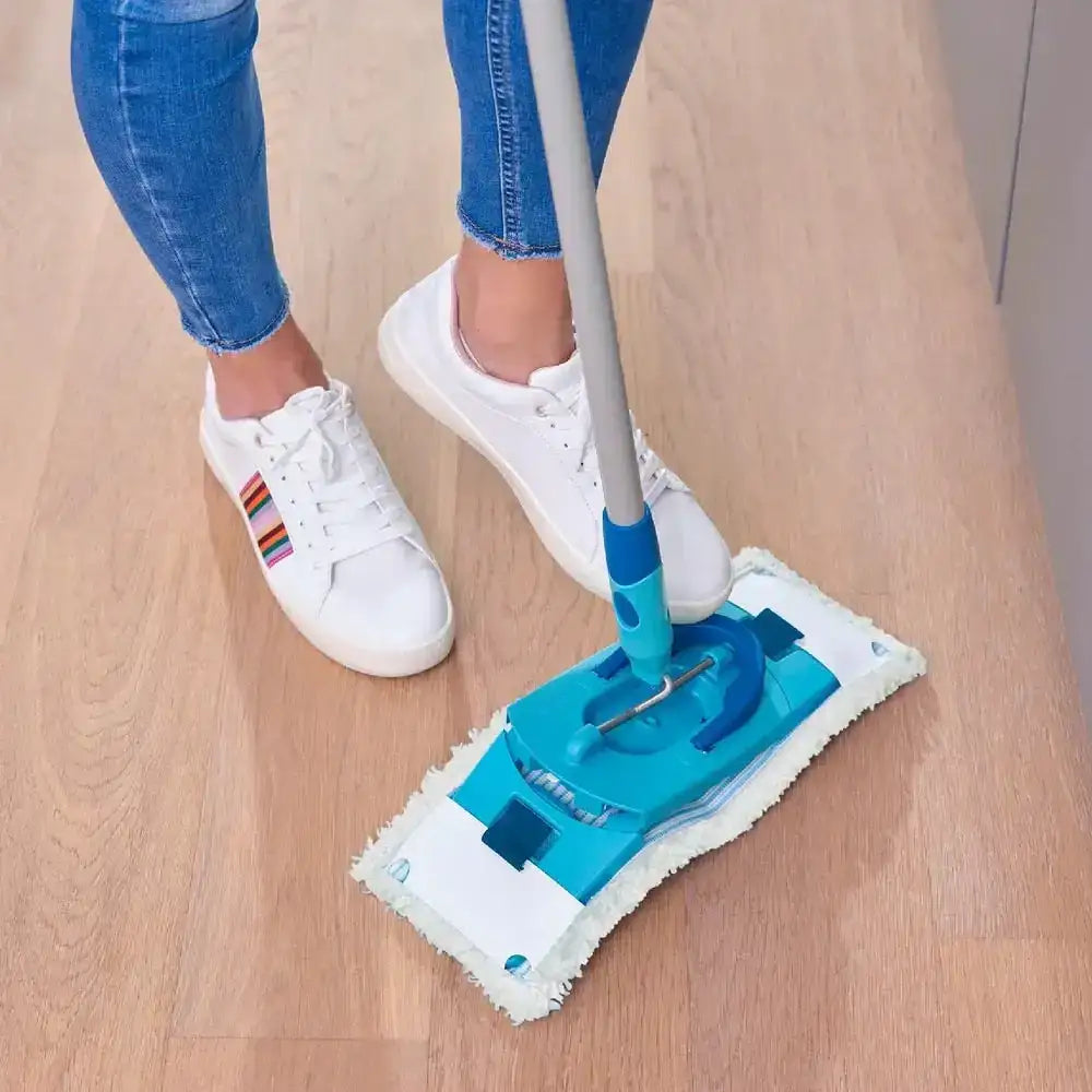 Person cleaning a wooden floor with a blue and white cleaning tool.
