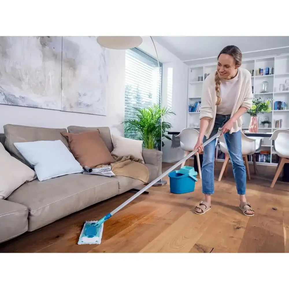 Woman cleaning a wooden floor with a mop in a living room.