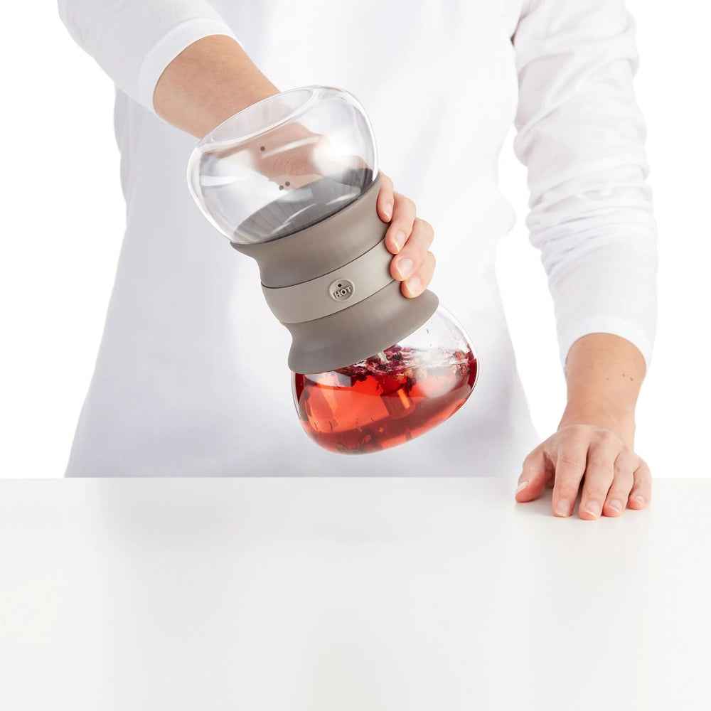 Person shaking a glass tea infuser 