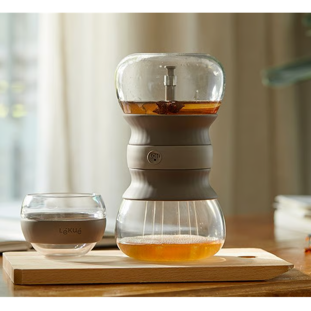 Glass tea infuser on a wooden surface with a blurred background 