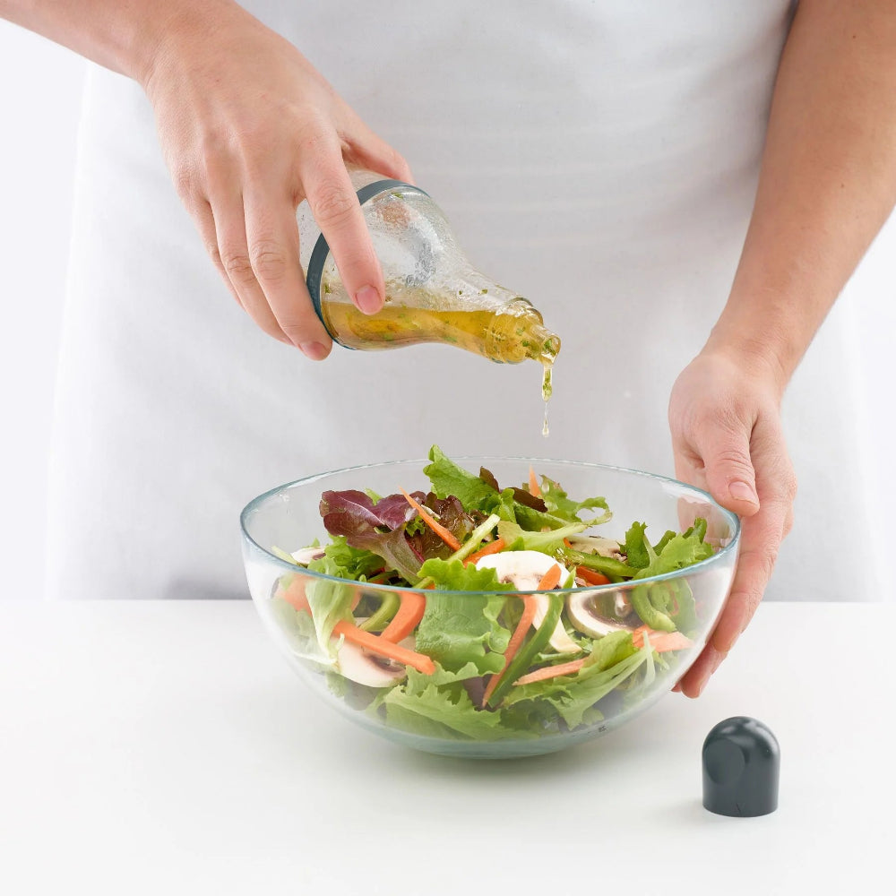 Person dressing a salad 