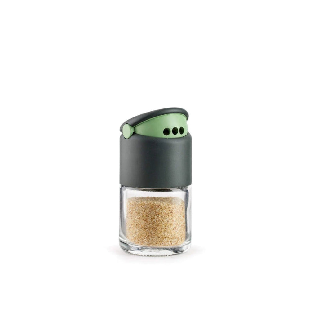Small glass container with a green lid on a white background