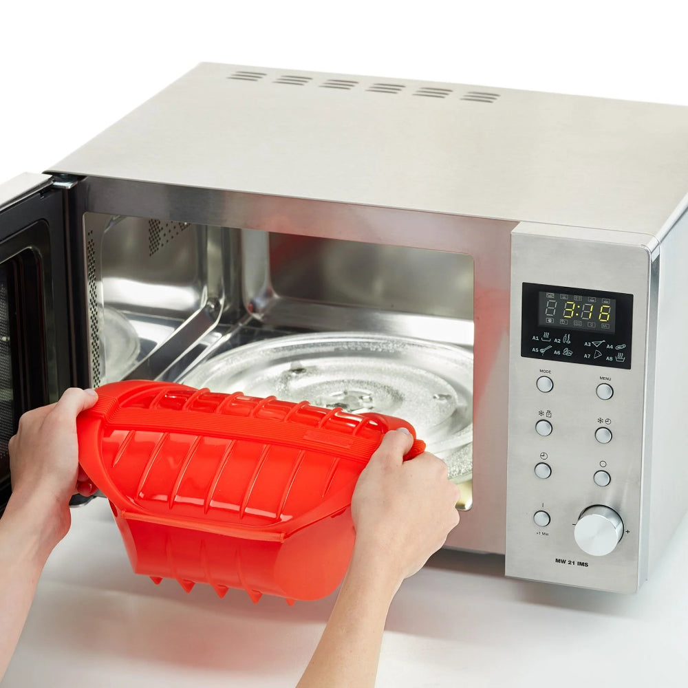 Person placing an orange container inside a microwave