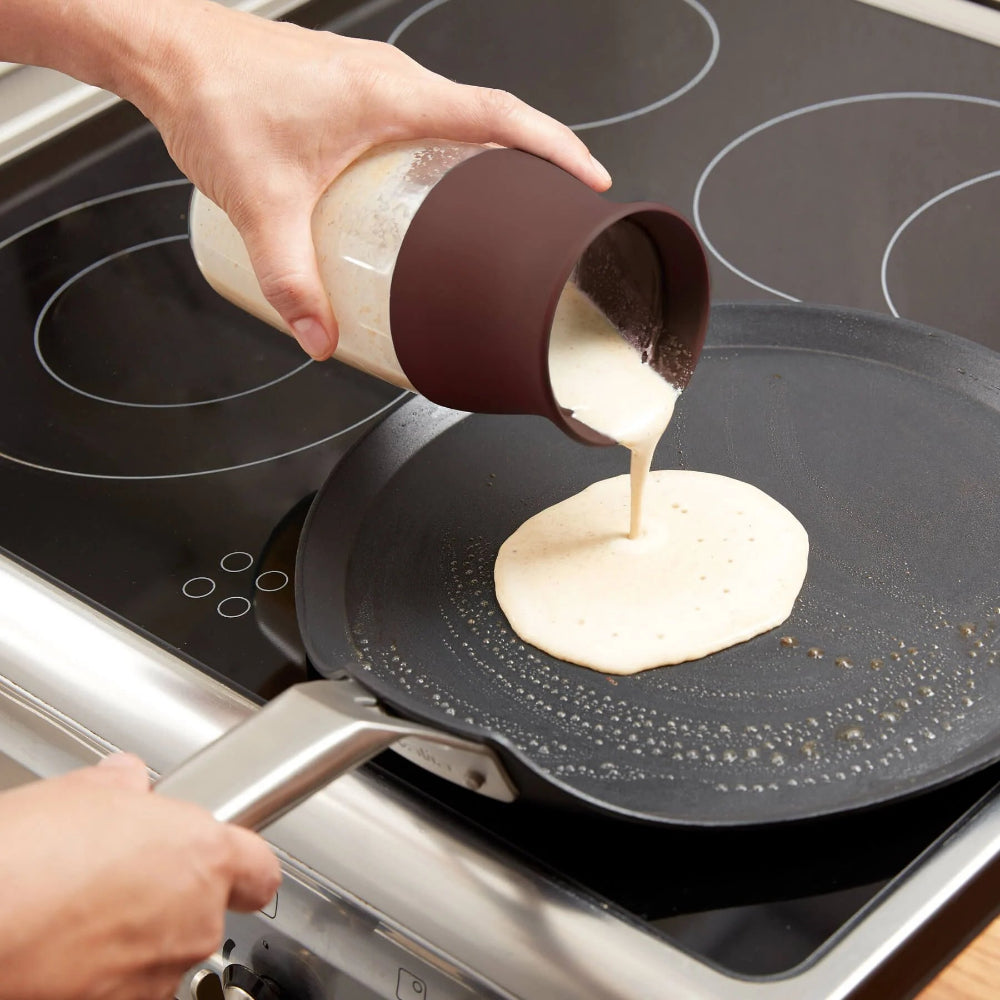 Person pouring batter into a frying pan