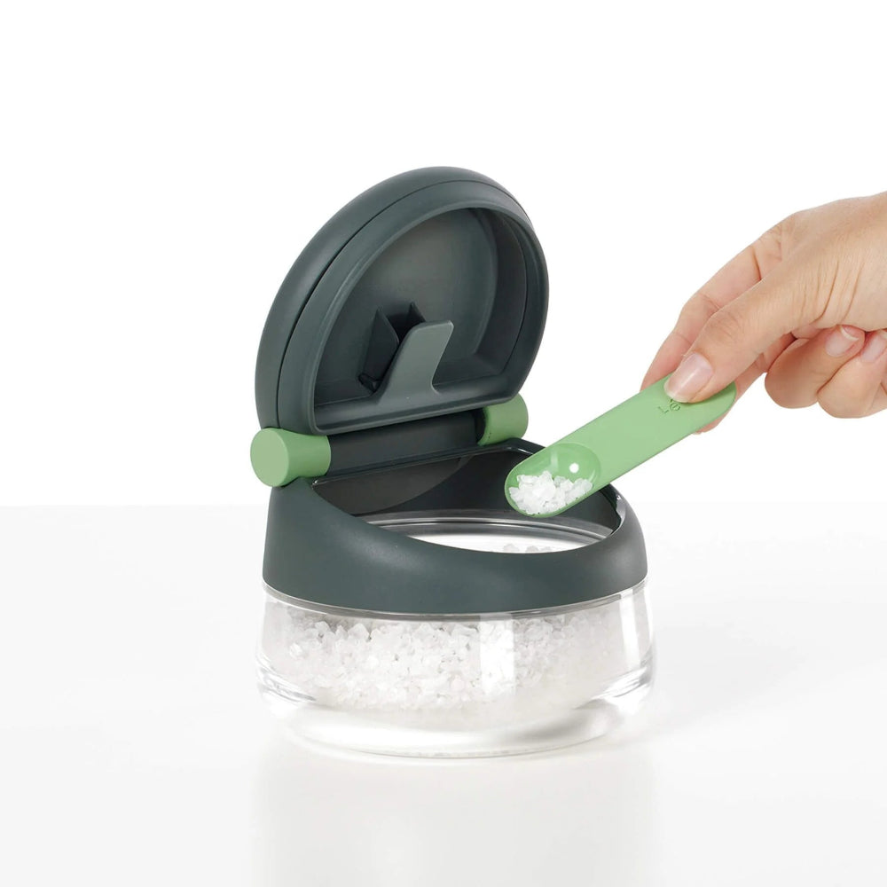 Person using a measuring spoon to measure salt 