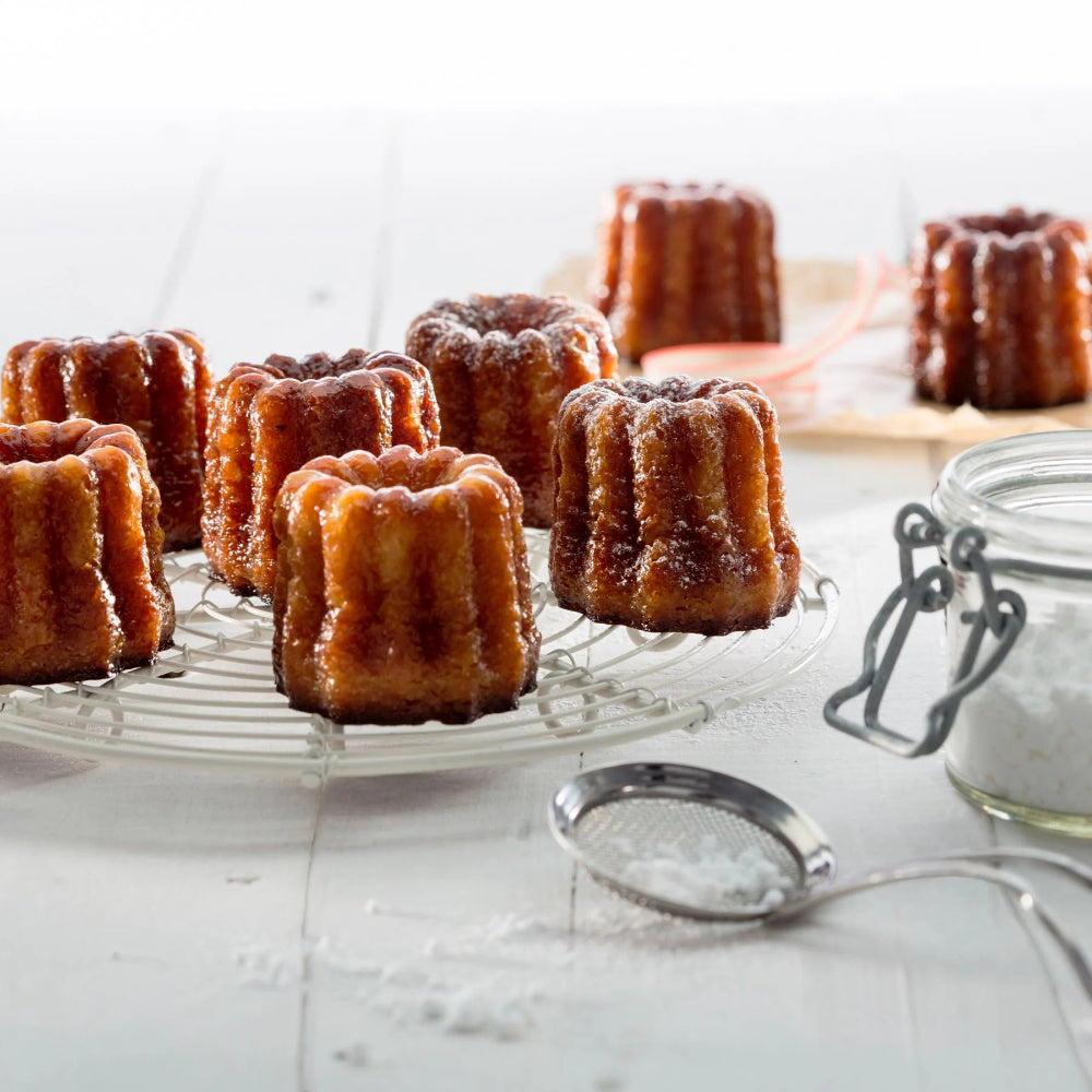 Fresh baked canele's on a cooling rack 