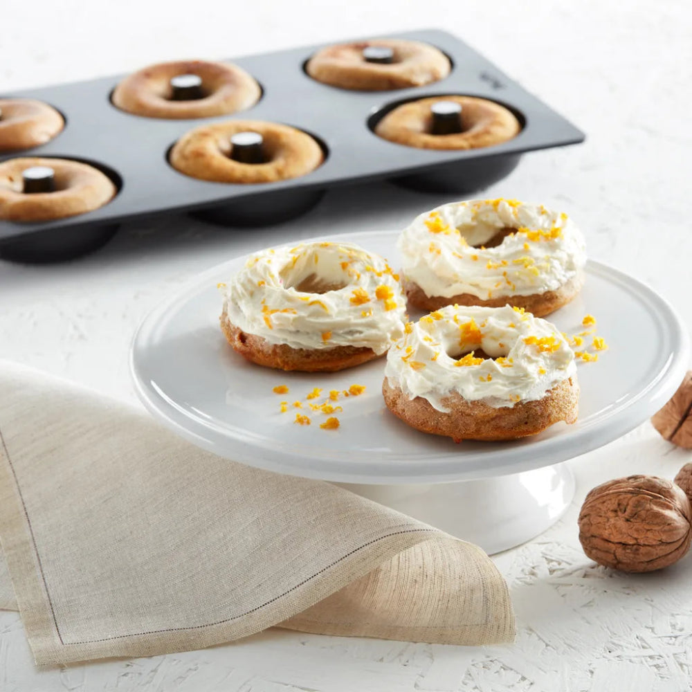 Doughnuts on a cake stand with doughnut mould in the background