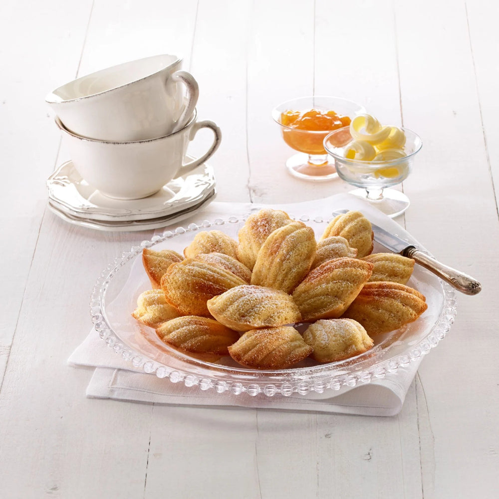 Plate of madeleine pastries on a wooden surface 