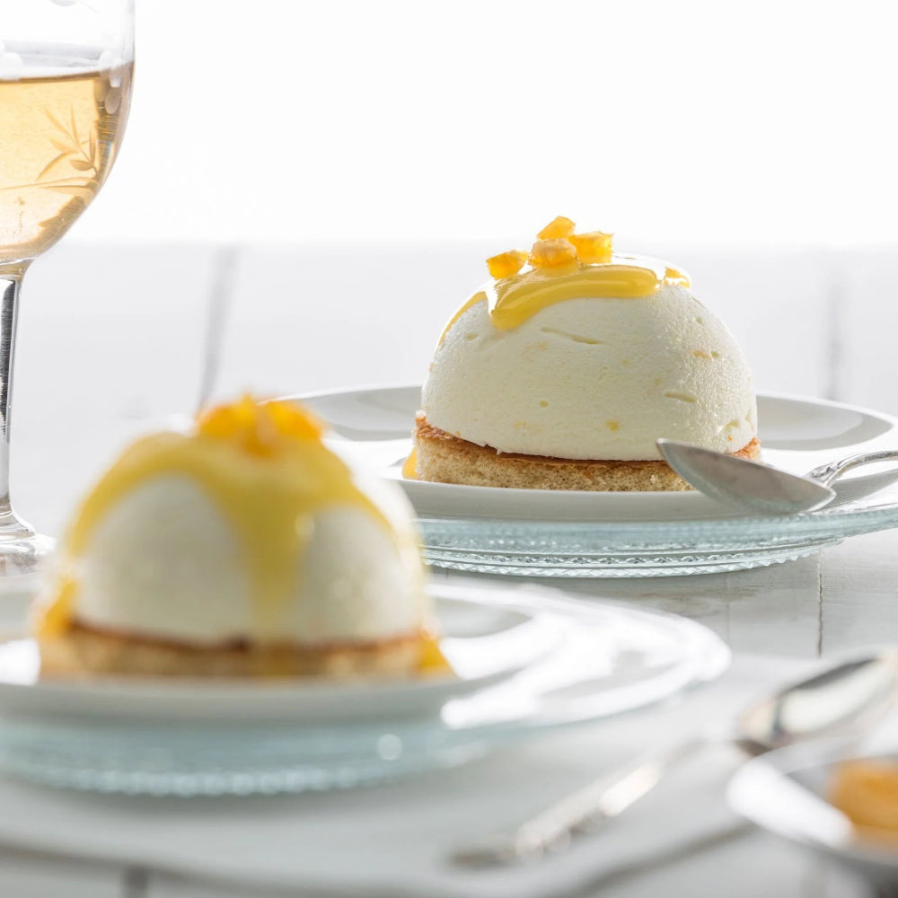 Spherical shaped desserts with a glass of wine in the background