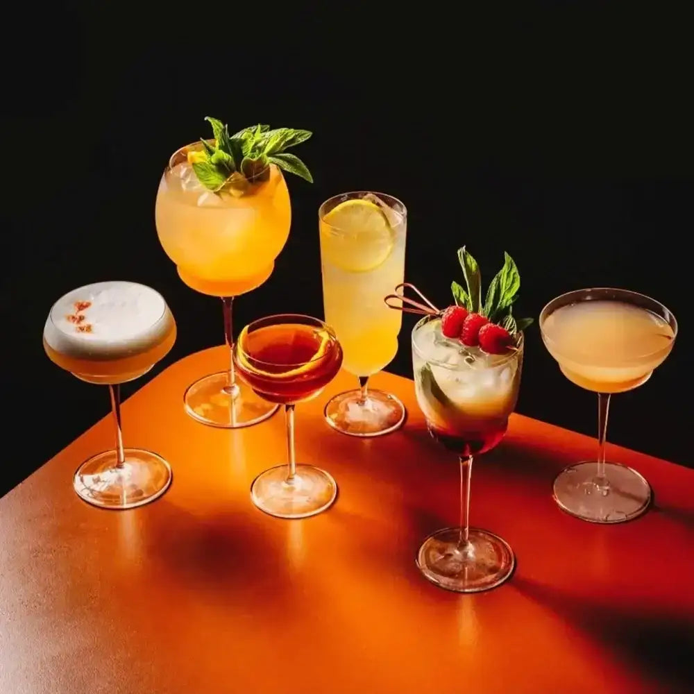 Assorted cocktails on a wooden surface with a dark background